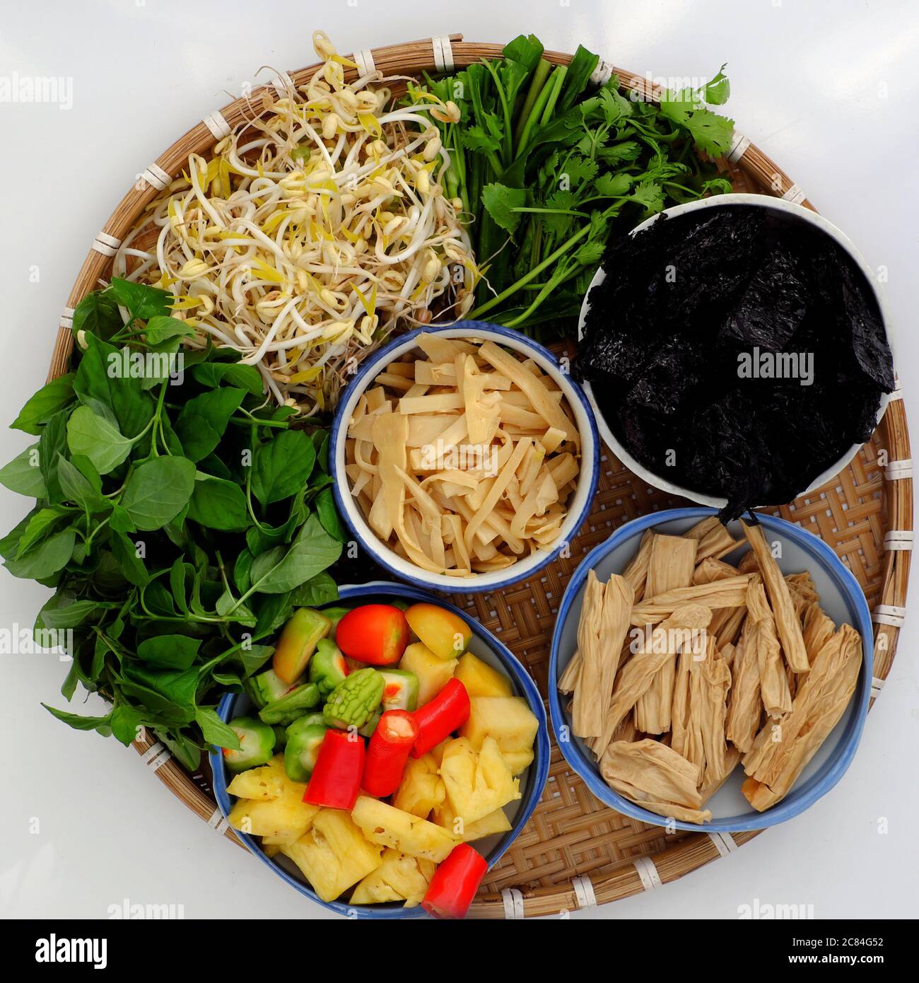Top view raw material ready for daily meal, Vietnamese vegan food for vegetarian, tofu skin, pine apple, bitter melon, seaweed, vegetable on white Stock Photo