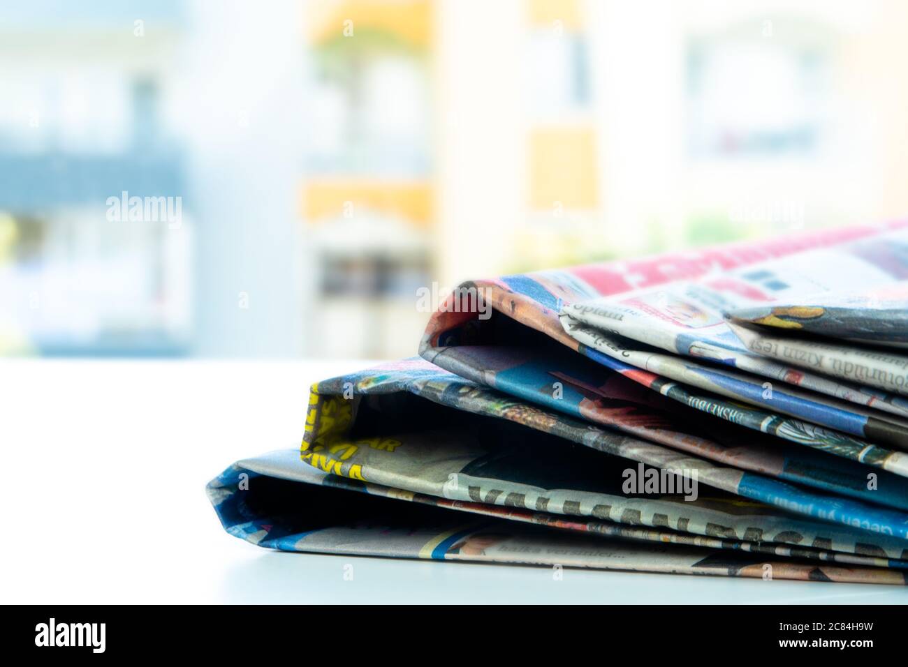 Pile of fresh morning newspapers on the table at office. Folded and stacked journals Stock Photo