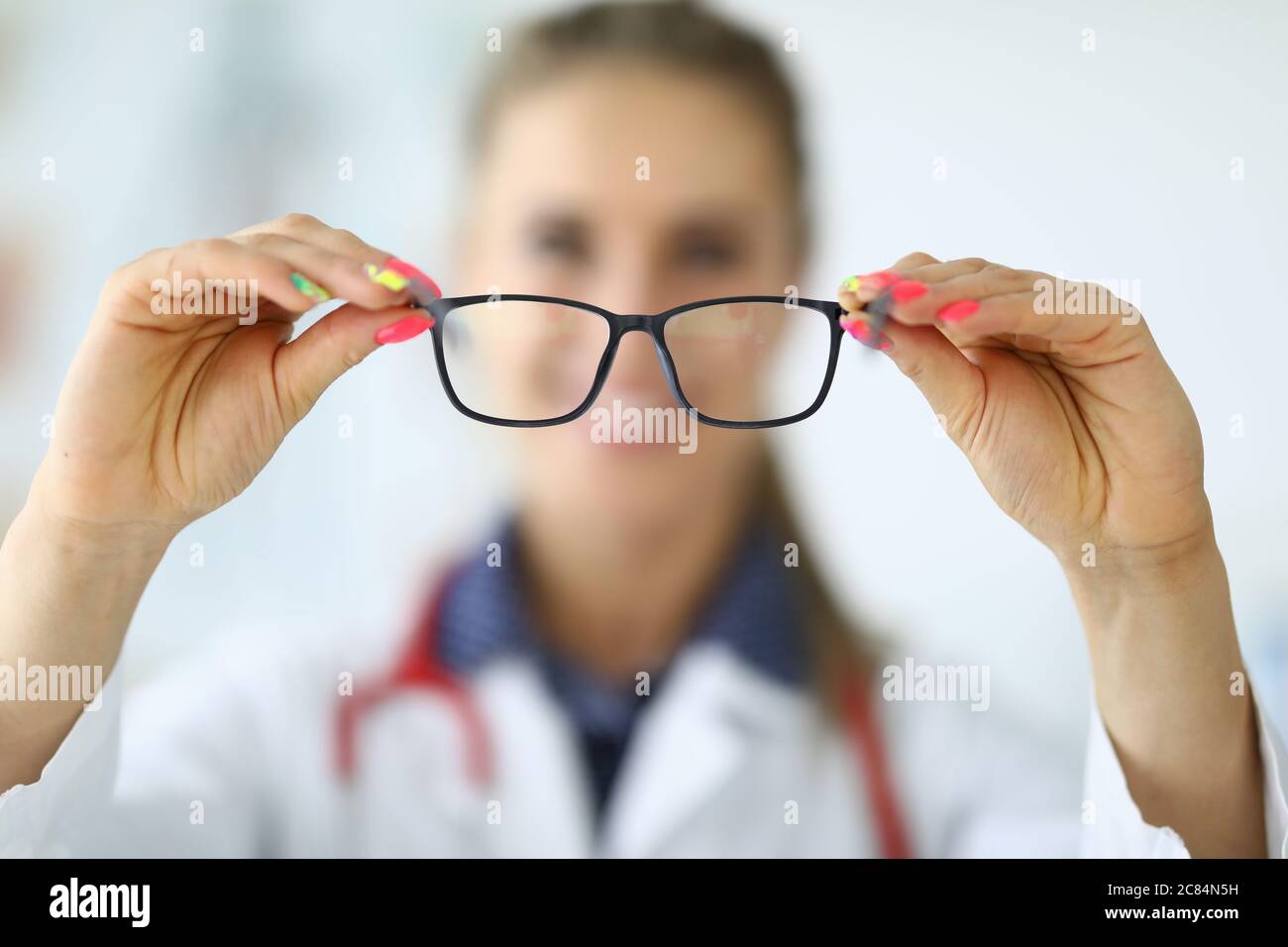 Woman doctor holding glasses in her hands closeup Stock Photo