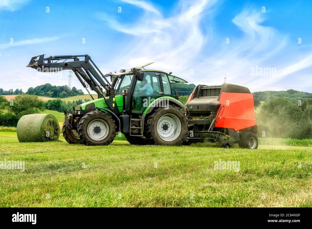 Big baler with film wrapper in use for grass silage preparation Stock Photo