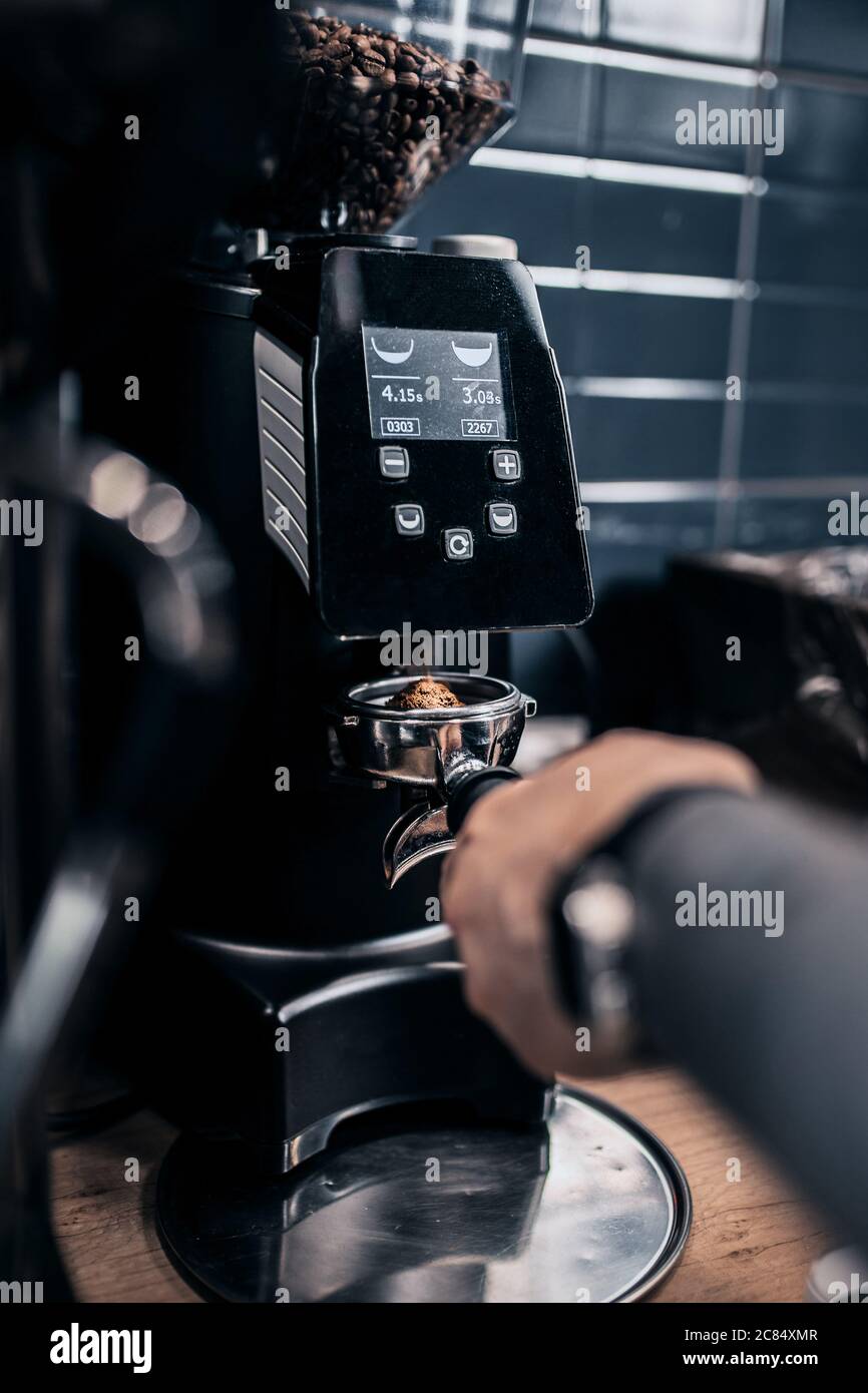 A professional barista transforms ground coffee beans into aromatic