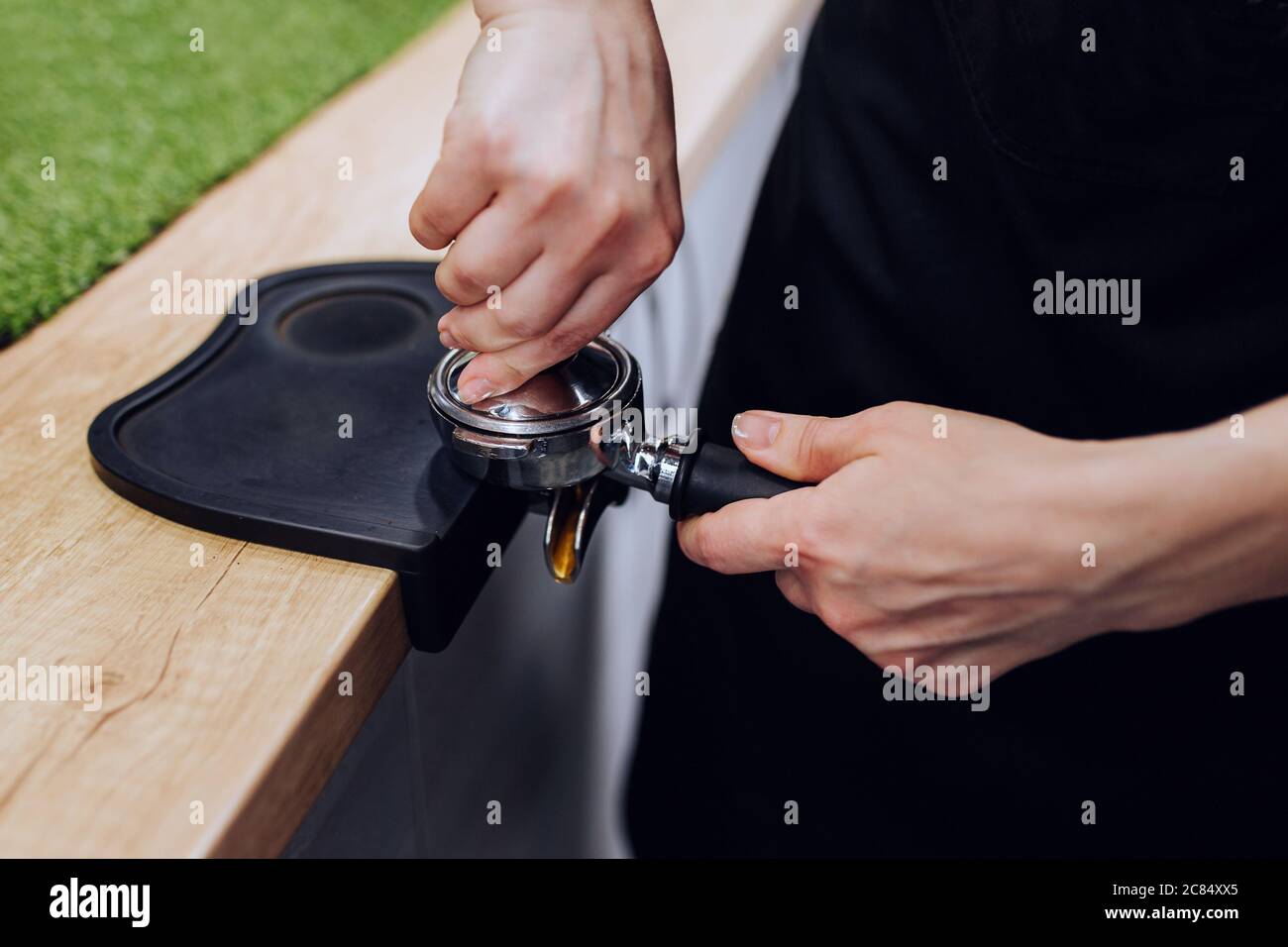 A professional barista transforms ground coffee beans into aromatic