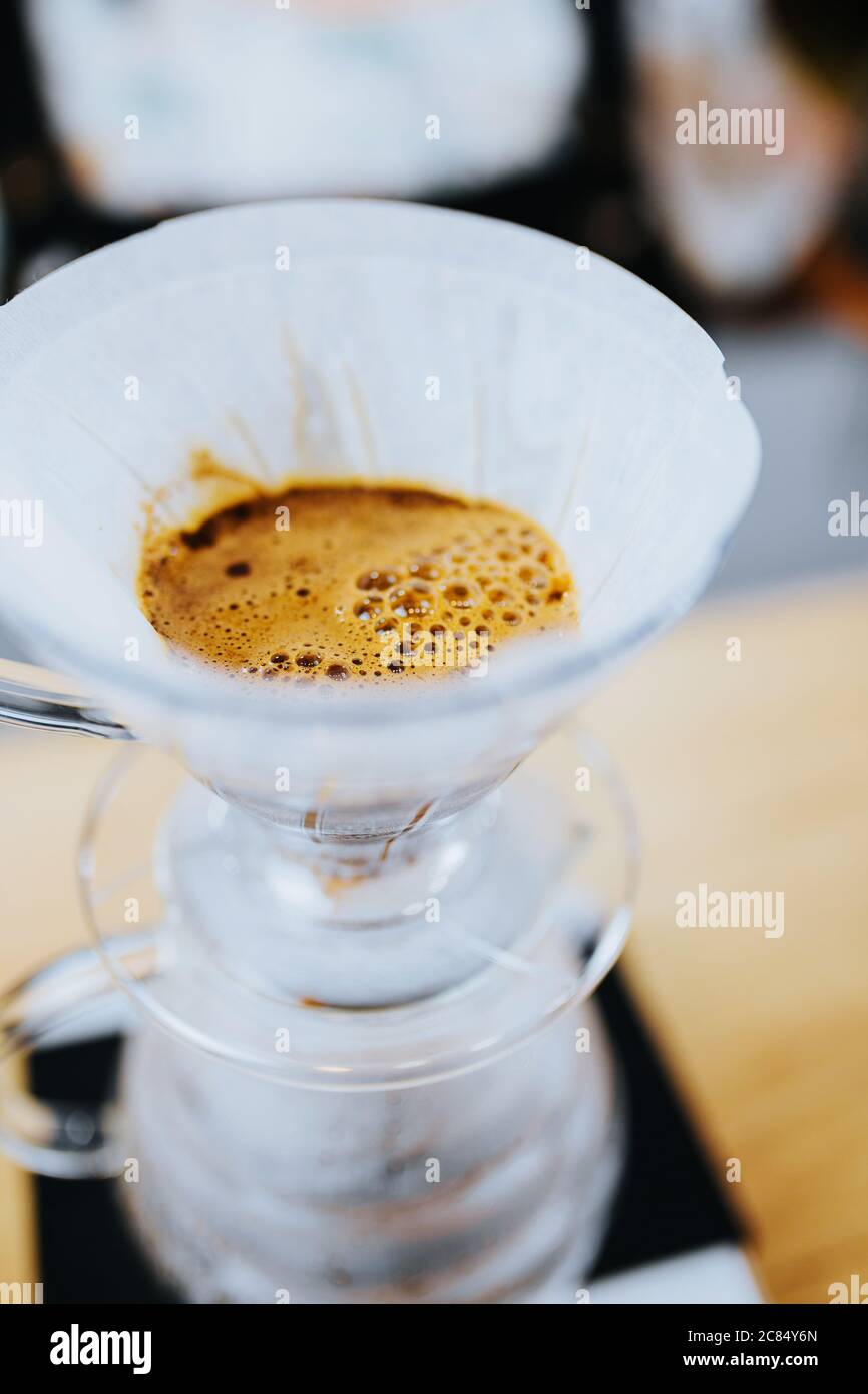 Drip coffee making with a funnel-shaped filter paper on a glass vessel Stock Photo