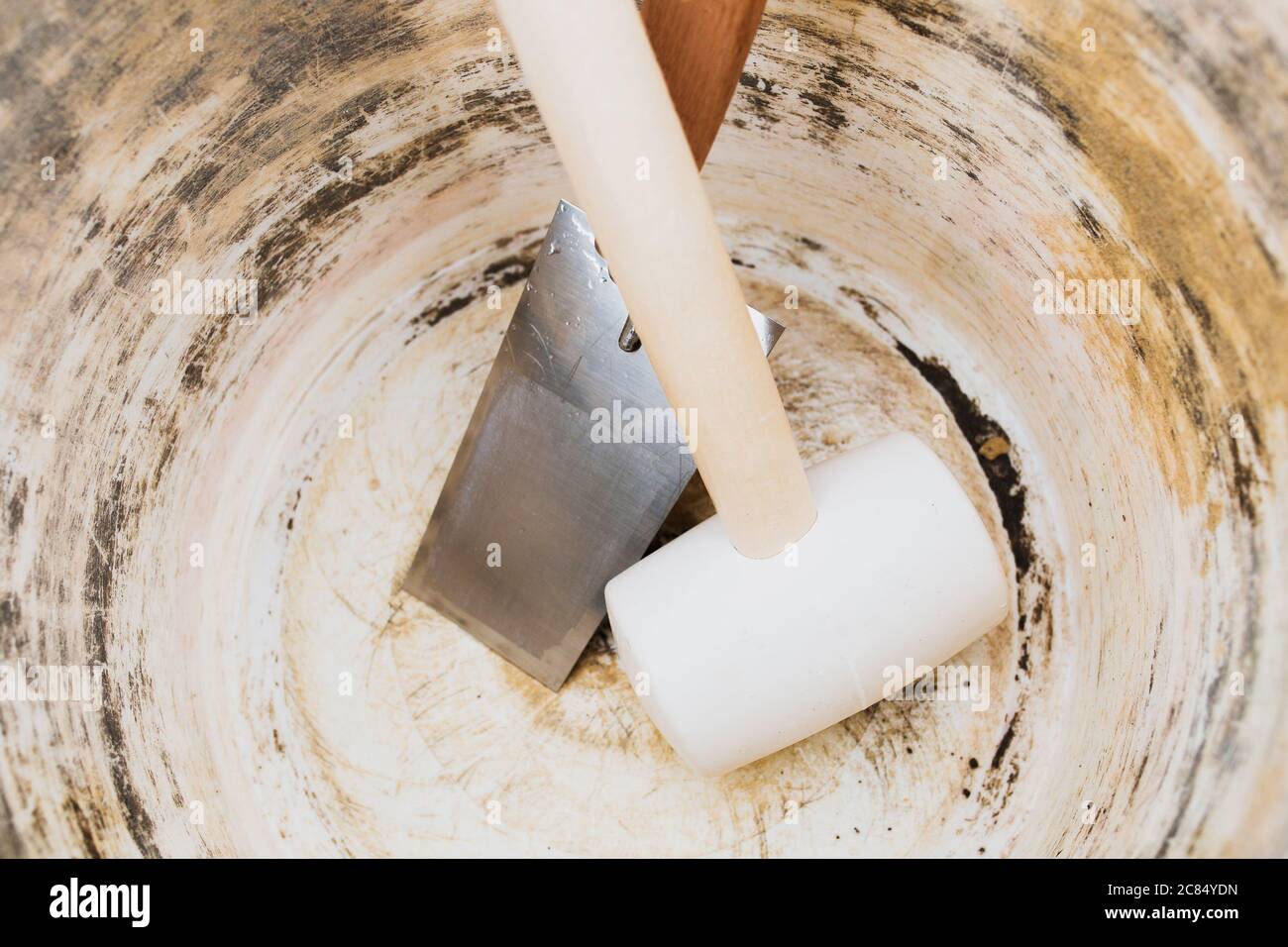 Empty mortar bucket at bricklayer workstation - mallet and trowel - work shift over Stock Photo