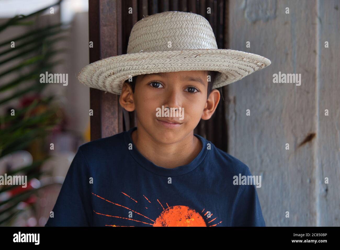 Young boy in a stylish white hat and blue tee shirt poses for the camera in Alter do Chao, Para State, Brazil Stock Photo