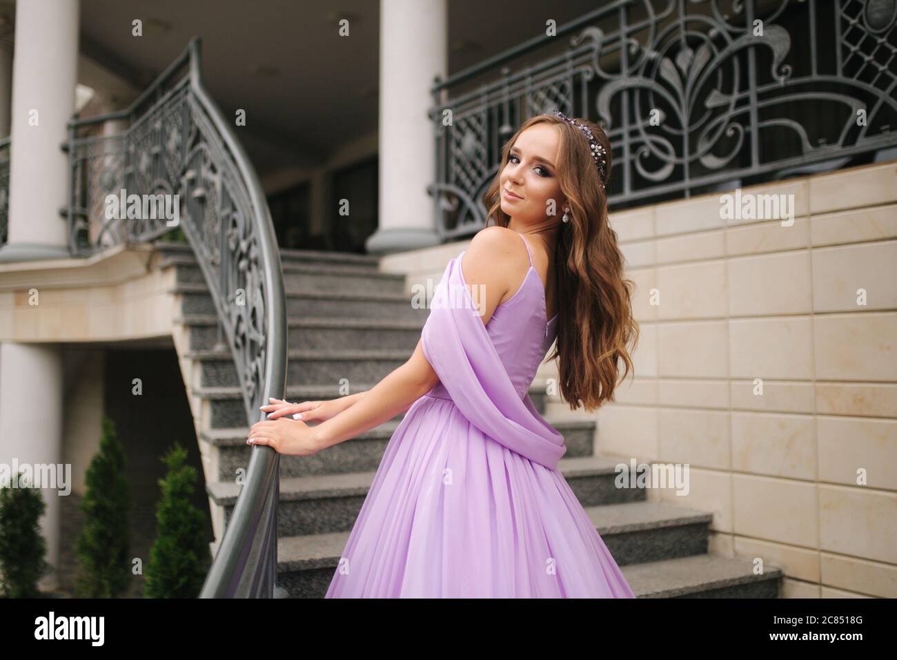 Portrait of elegant woman in purple evening dress walking outdoors by ...