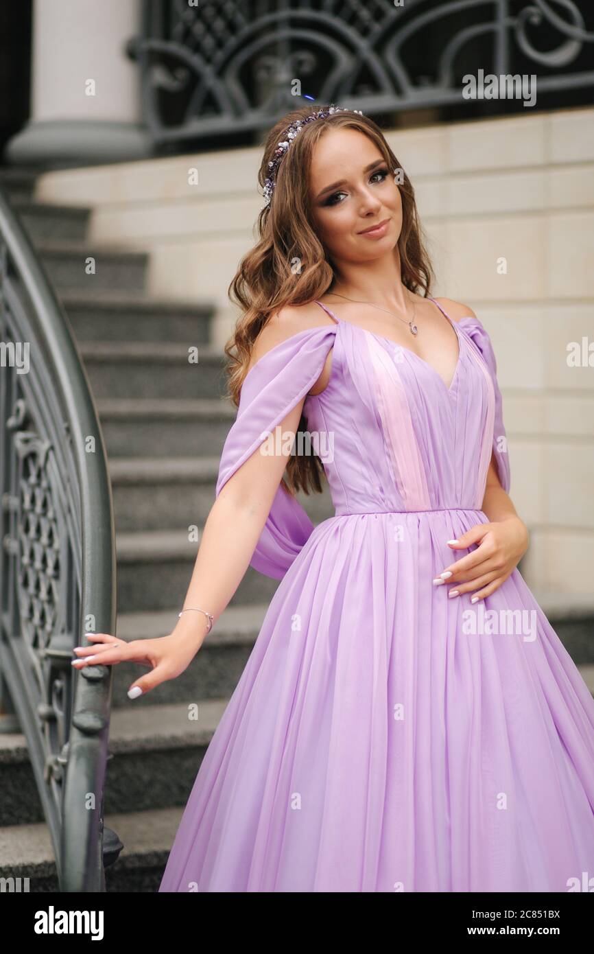 Portrait of elegant woman in purple evening dress walking outdoors by  restaurant Stock Photo - Alamy