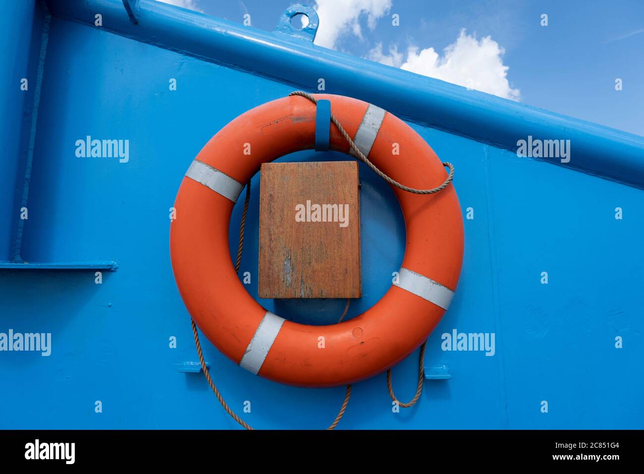 Orange float ring on a blue metal wall Stock Photo