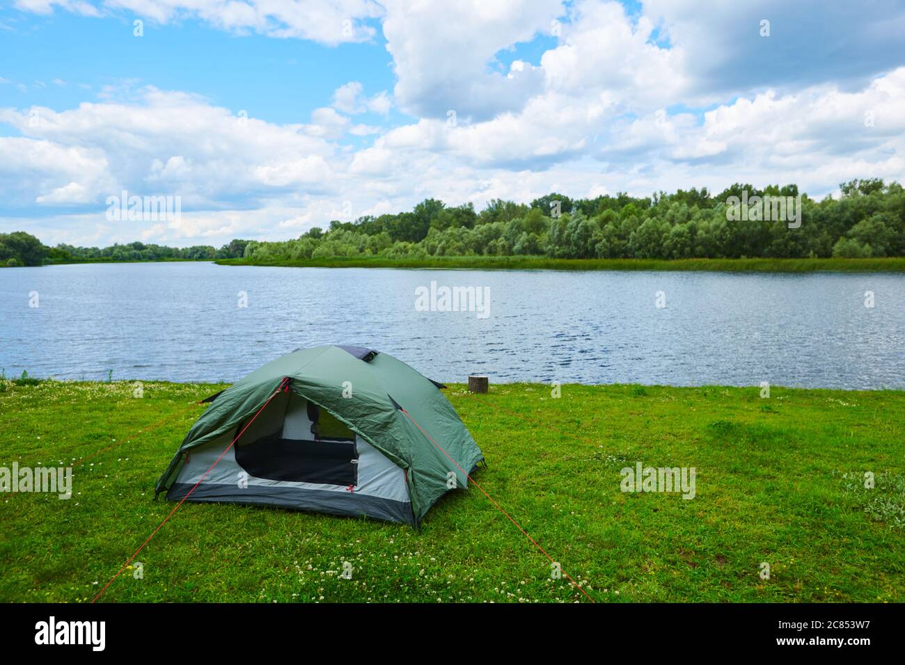 Camping green tent in forest near lake Stock Photo - Alamy