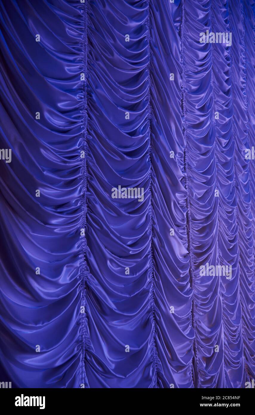 Large purple curtain with spot light and fading into dark Stock Photo