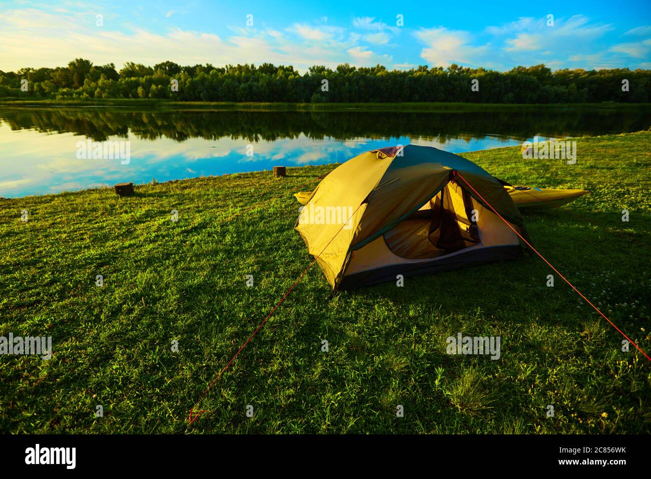 Camping green tent in forest near lake Stock Photo - Alamy