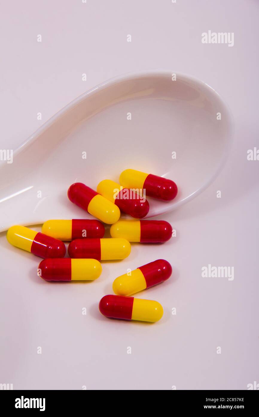 Yellow and red capsules outside the cover with white background Stock