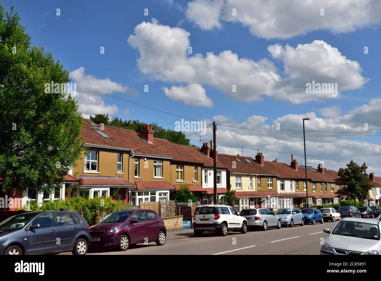 Row of terraced houses with cars parked in front along street, Horfield, Bristol Stock Photo