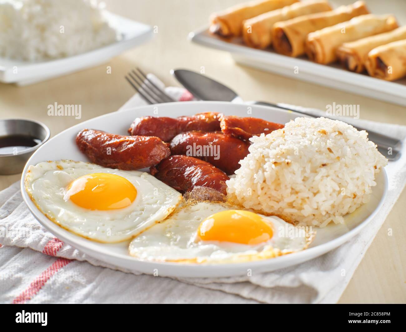 filipino silog breakfast with garlic fried rice, longsilog, and two
