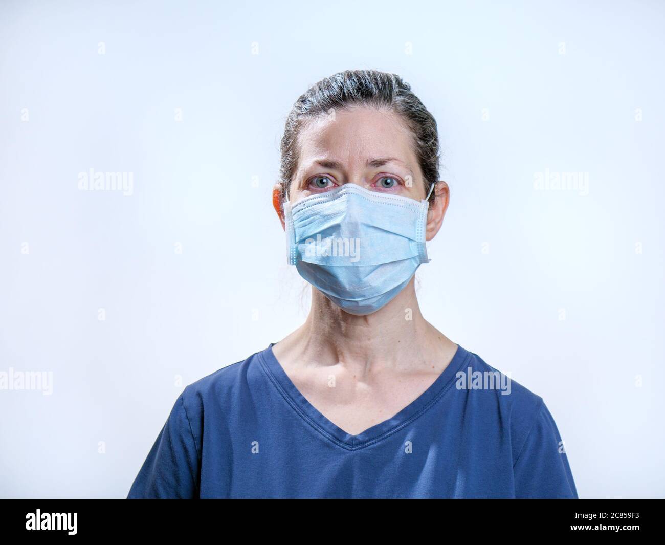 Female healthcare worker wearing surgical face mask. Photo taken during COVID-19 pandemic. Model portrayal. Stock Photo