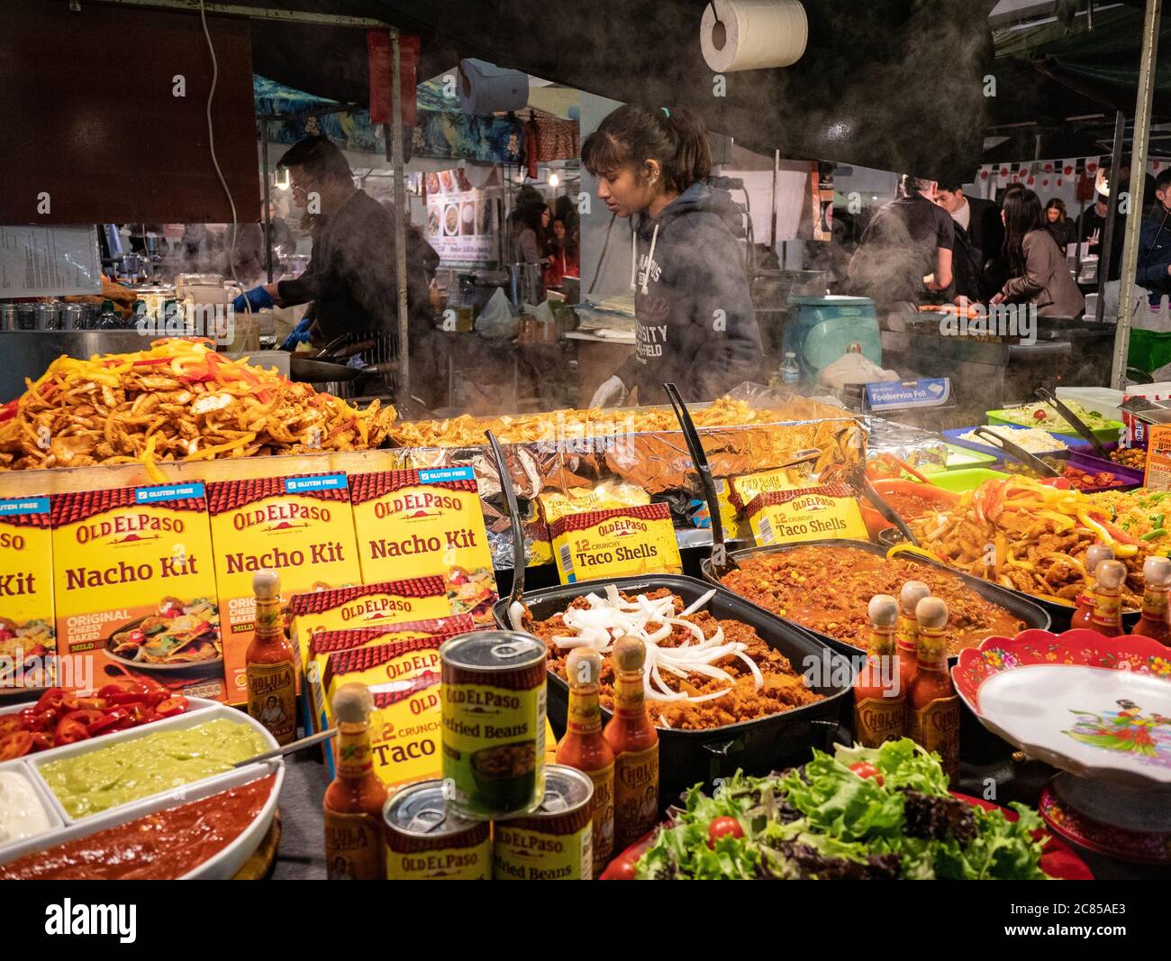 London, UK - November 04 2018: A lady works hard on a Mexican food stall at Brick Lane market in London Stock Photo