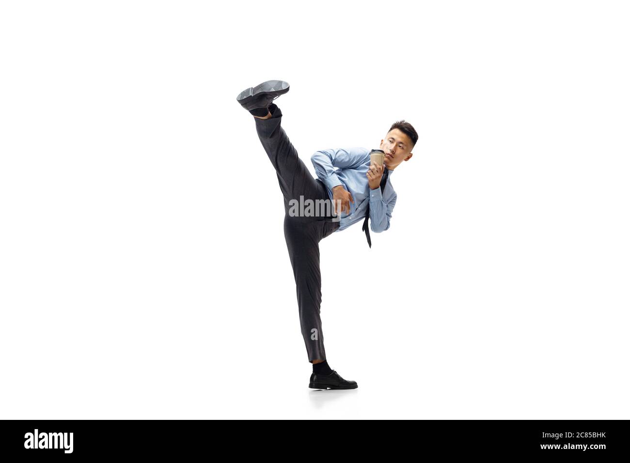 Kick. Man in office clothes practicing taekwondo on white background like  professional player, sportsman. Unusual look for businessman in motion,  action with ball. Sport, healthy lifestyle, creativity Stock Photo - Alamy