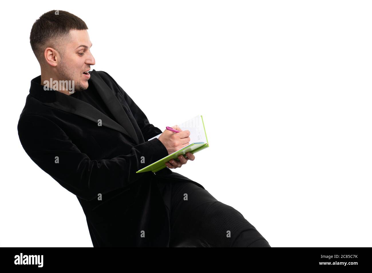 Young happy businessman making notes in a notebook Stock Photo
