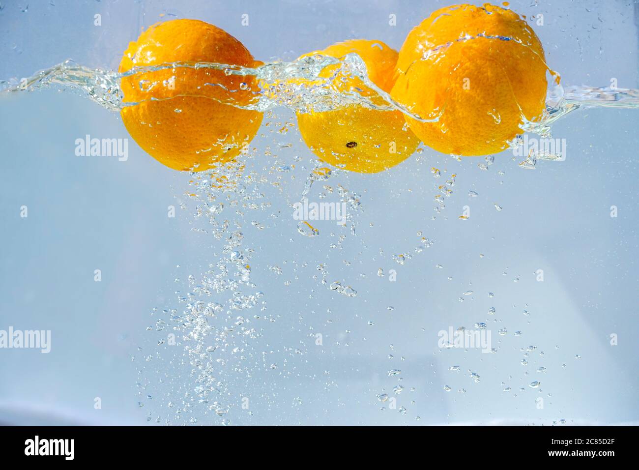 oranges fall into the water with bubbles Stock Photo Alamy