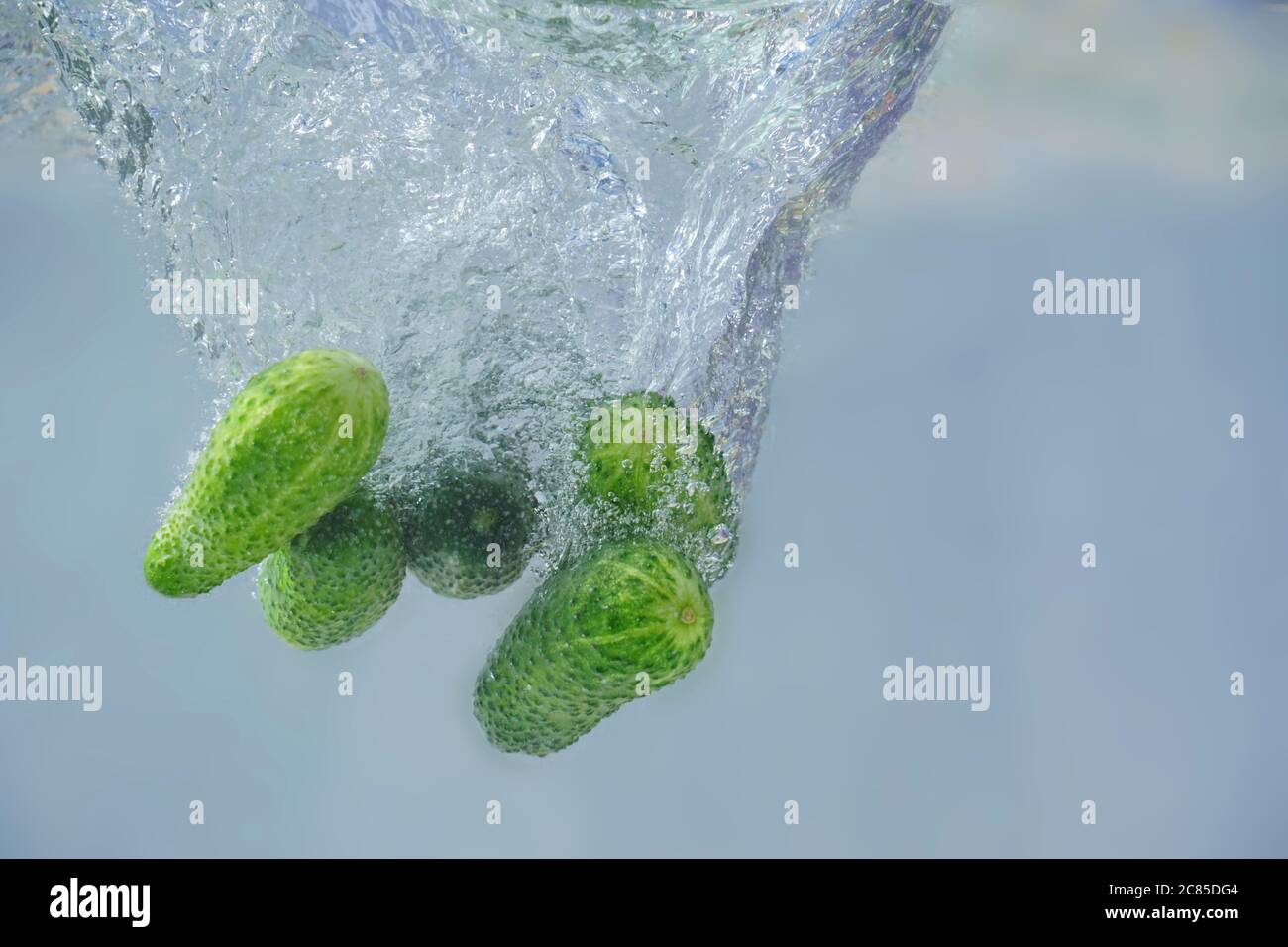 cucumbers fall into the water with bubbles Stock Photo
