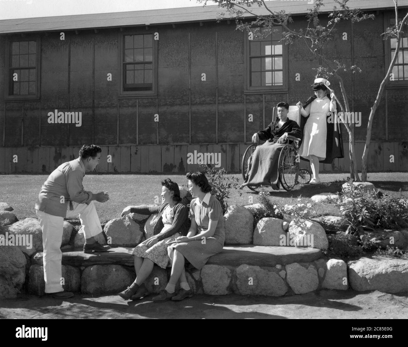 Nurse Aiko Hamaguchi with patient Tom Kano, Young Man talking to Young  Women seated on Stone Bench in foreground, Relocation Center, Manzanar,  California, USA, Ansel Adams, Manzanar War Relocation Center photographs,  1943