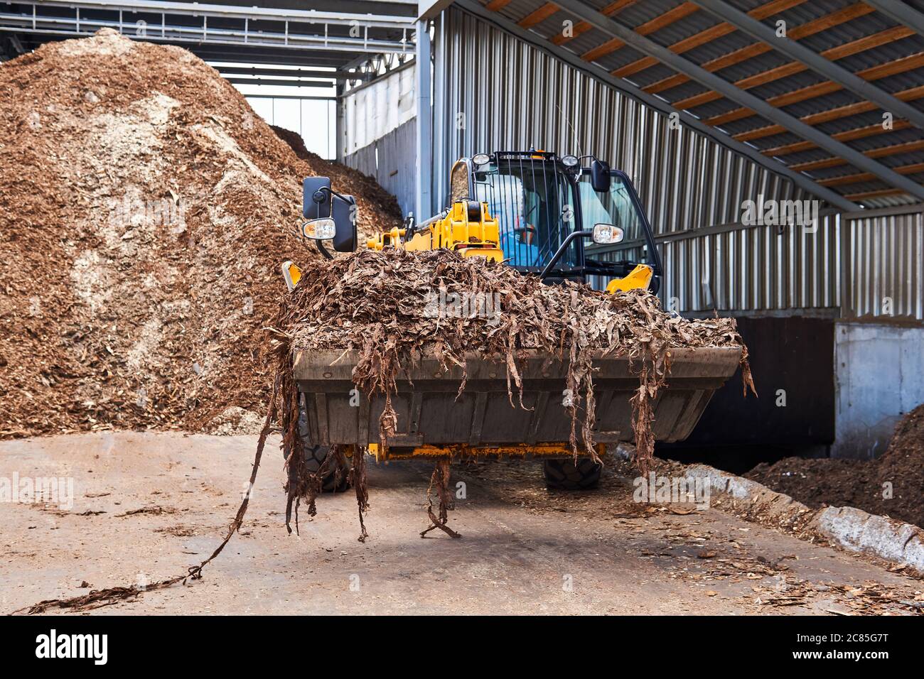 bucket loader moving wood bark in a woodworking industry Stock Photo