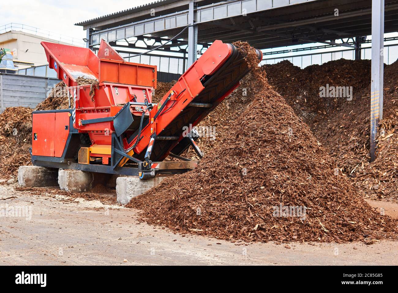 industrial wood shredder producing wood chips from bark Stock Photo