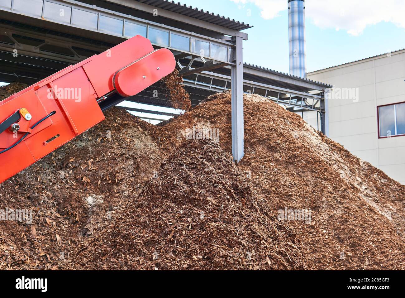 close-up conveyor of an industrial wood shredder producing wood chips from bark Stock Photo