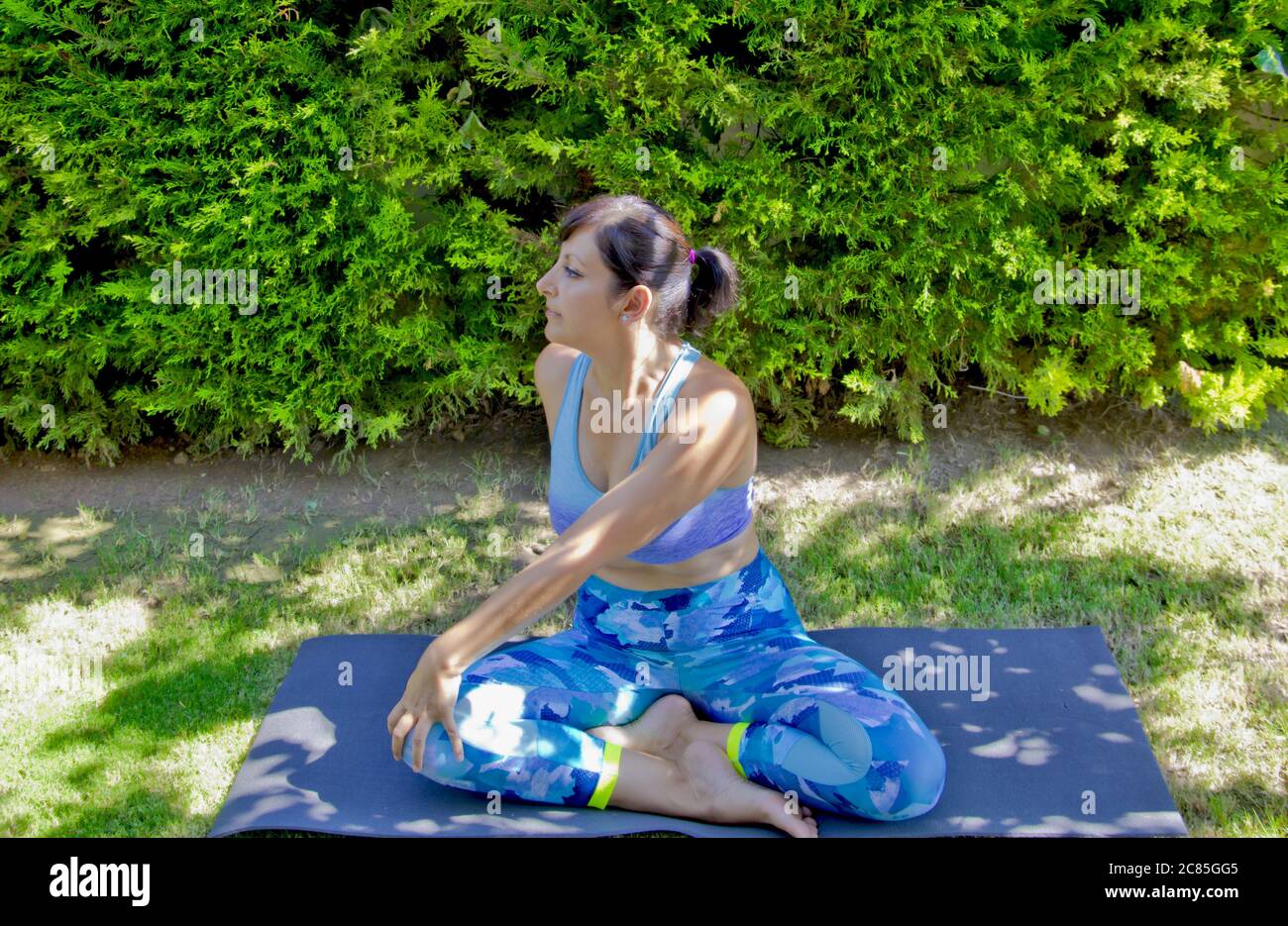 Beautiful young woman doing yoga in the garden Stock Photo