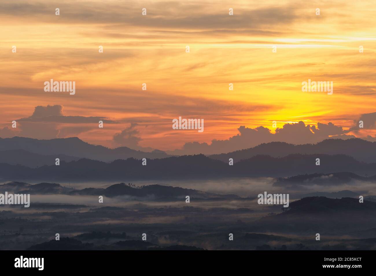 A morning view of a mist-covered mountain and the sun rising from the ...