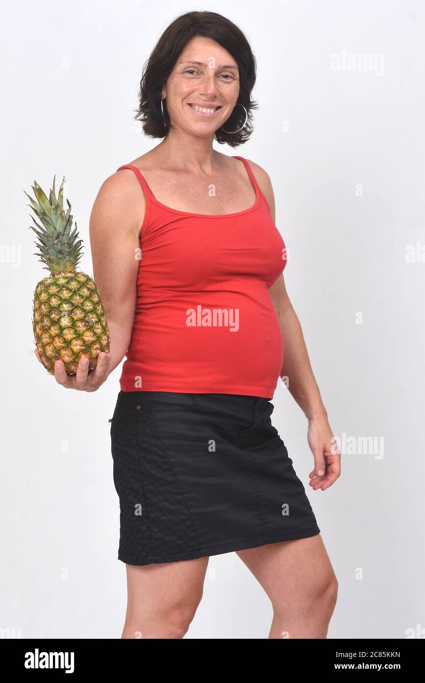 pregnant woman holding a pineapple on white background Stock Photo Alamy