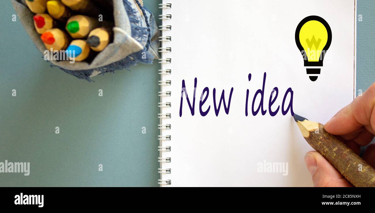 Hand writing 'new idea' on white note, isolated on blue background ...