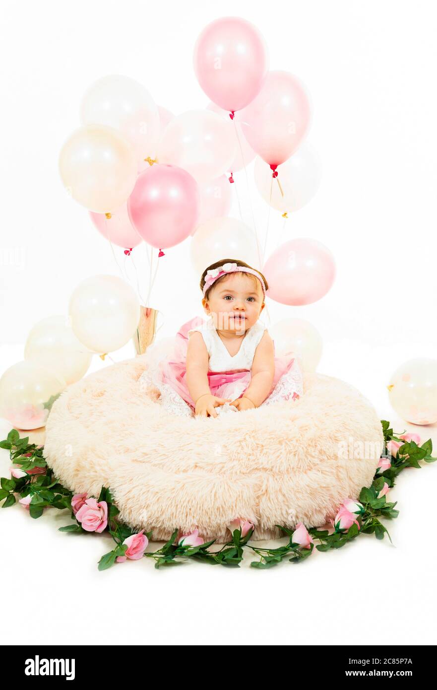 Vertical lifestyle portrait of a baby girl on her first birthday. Stock Photo