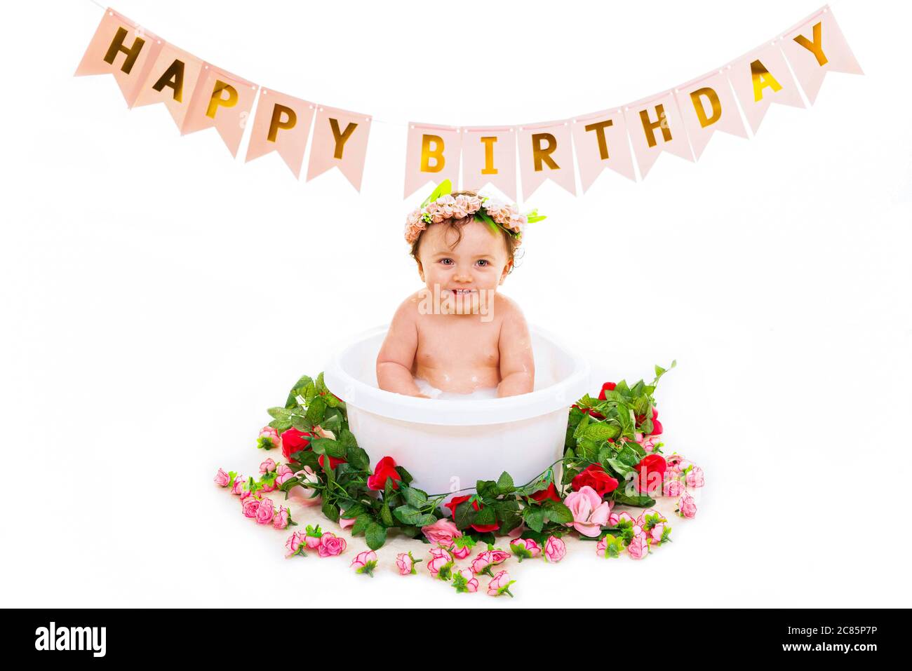Horizontal lifestyle portrait of a baby girl in a bath on her first birthday. Stock Photo