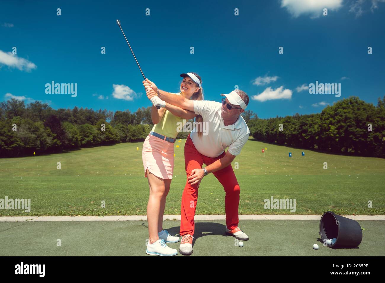 Golf pro teaching a woman student of the driving range Stock Photo Alamy