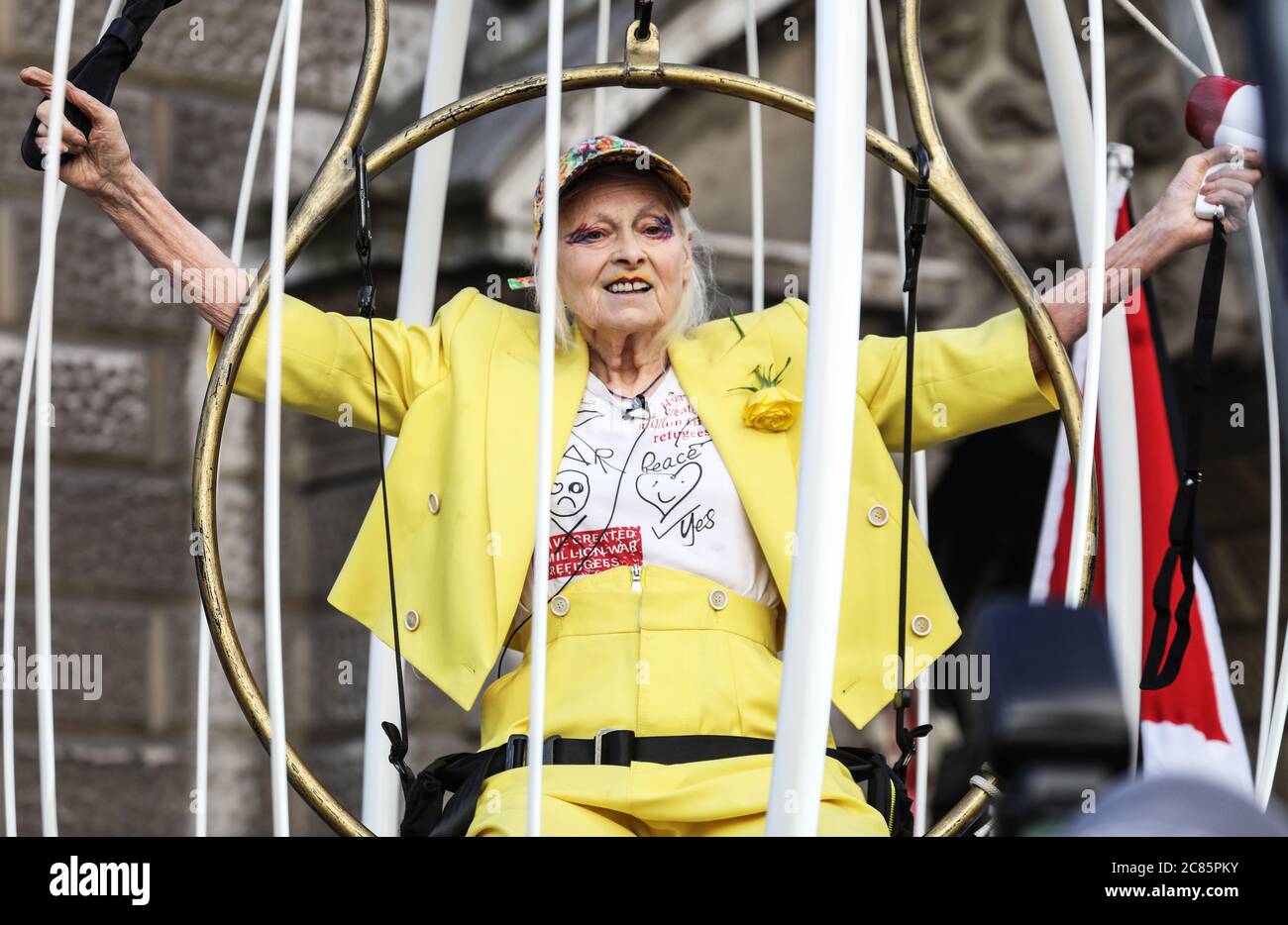 London, UK. 21st July, 2020. Vivienne Westwood seen suspended 10ft inside a bird cage during the protest.Fashion designer and business woman Dame Vivienne Westwood is suspended in a ten foot high bird cage outside the Old Bailey in London to protest against the US extradition of Julian Assange. Credit: SOPA Images Limited/Alamy Live News Stock Photo
