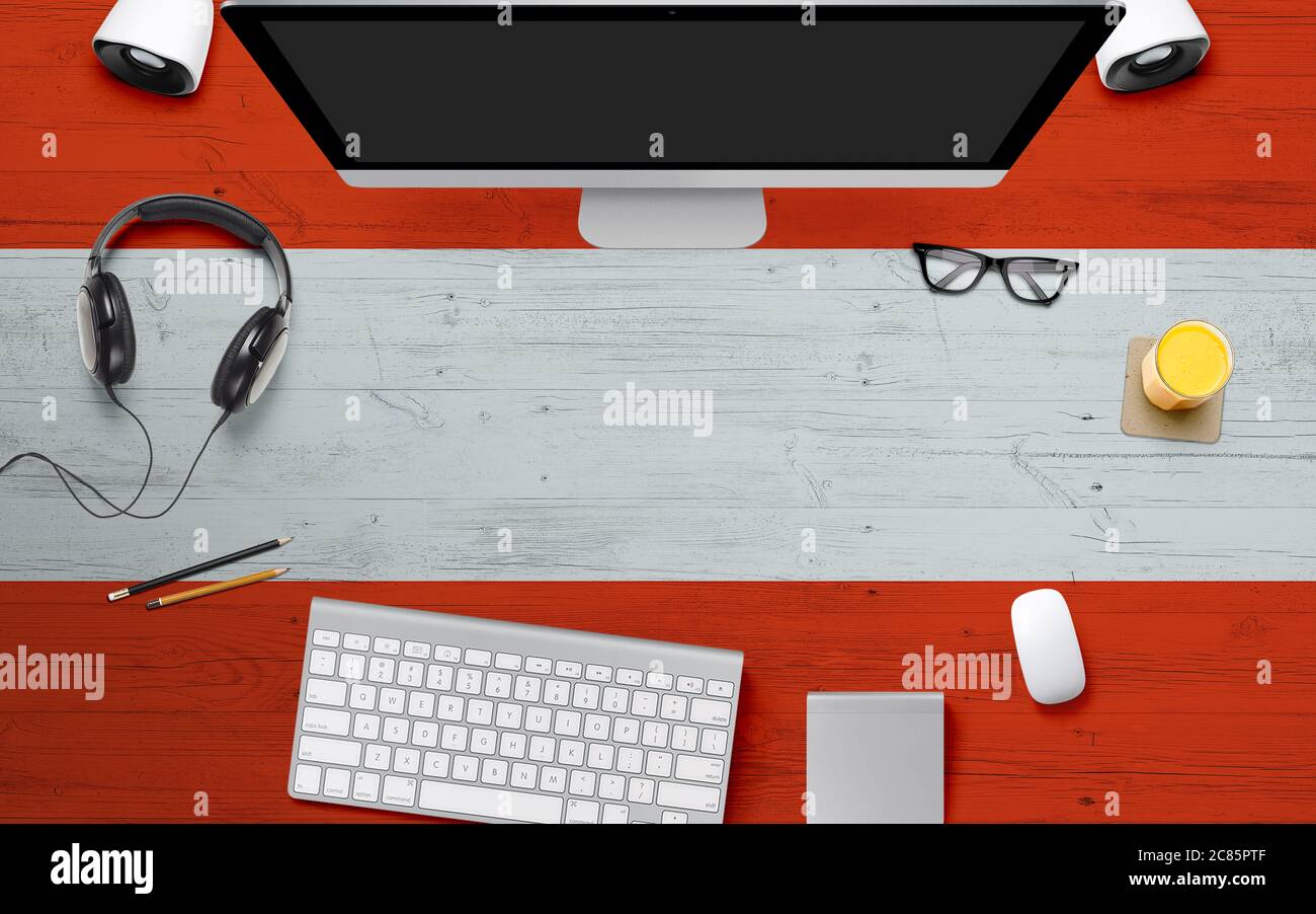 Austria flag background with headphone,computer keyboard and mouse on national office desk table.Top view with copy space.Flat Lay. Stock Photo