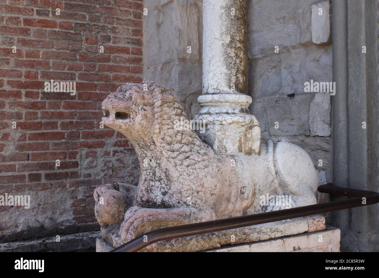 a stone sphinx supports a column at the entrance to a Catholic cathedral Stock Photo