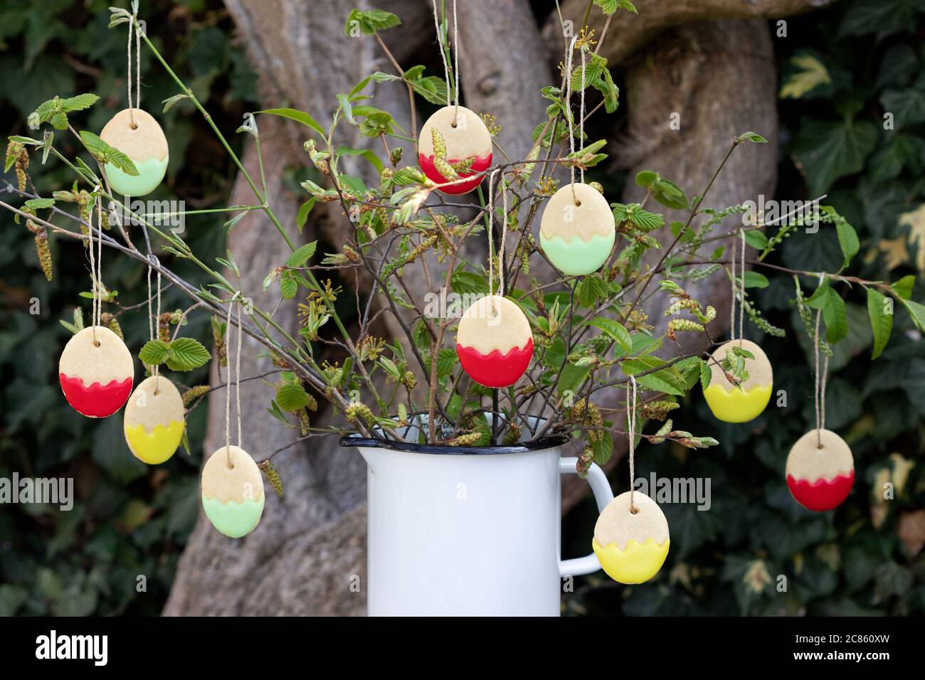 easter bakery biscuits in form of easter eggs hangign on branches Stock Photo