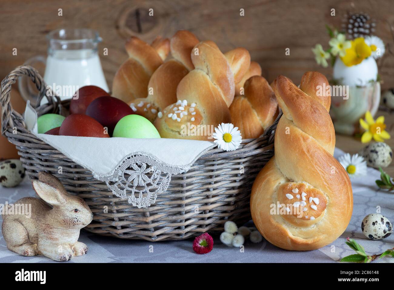 easter table decoration with yeast easter bunnies and eggs in basket Stock Photo