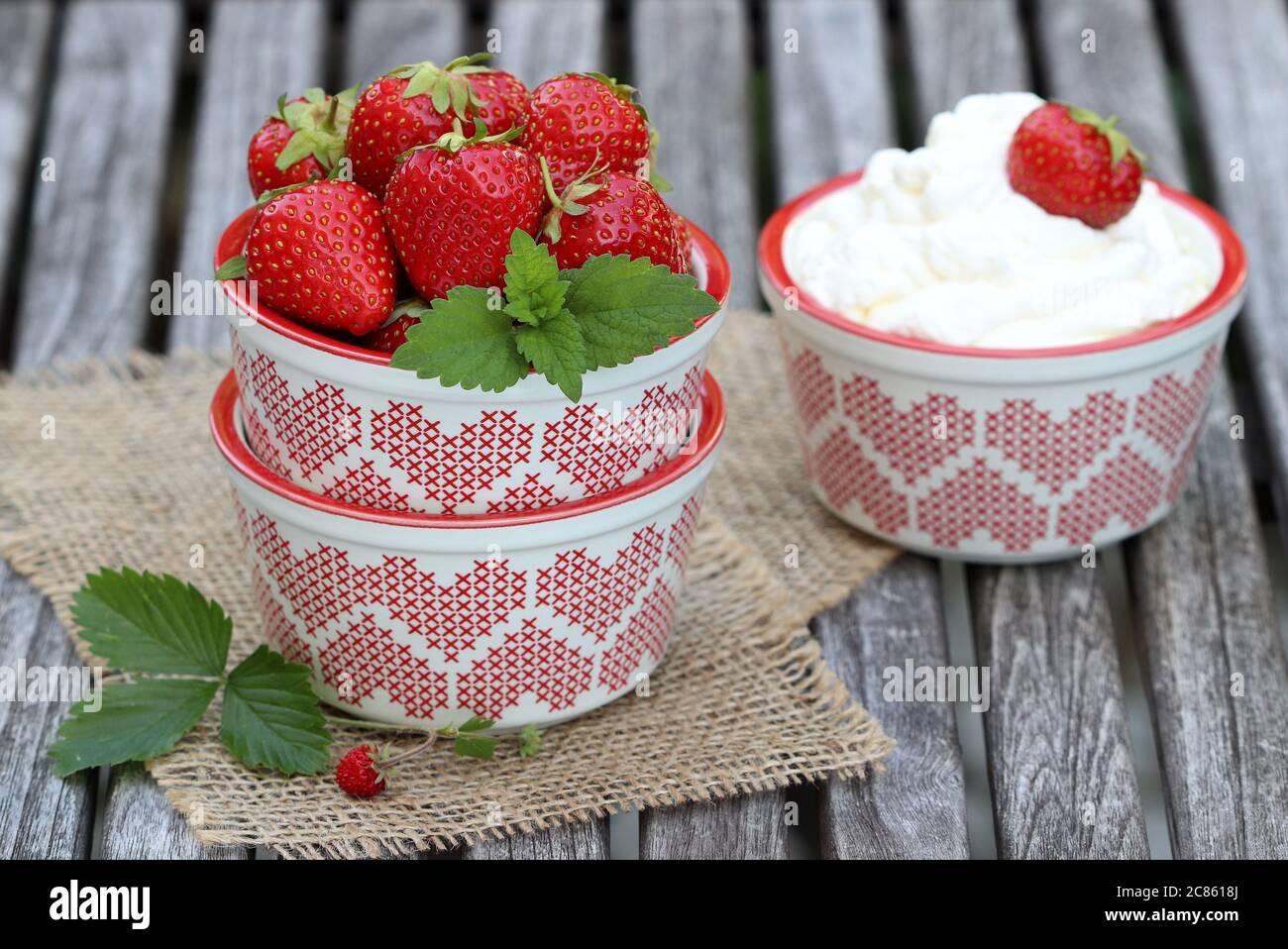 table decoration with fresh starawberries in bowl and whipped cream Stock Photo