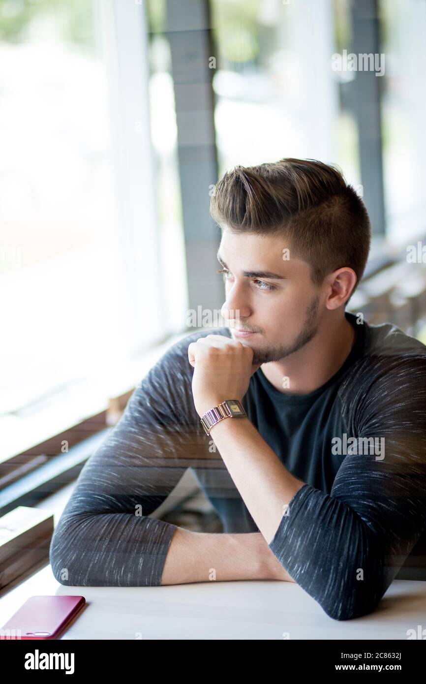 Caucasian man with stylish haircut looking pensively at the window while waiting for his girlfriend at cafe Stock Photo - Alamy Caucasian man with stylish haircut looking pensively at the window while waiting for his girlfriend at cafe Stock Photo - Alamy