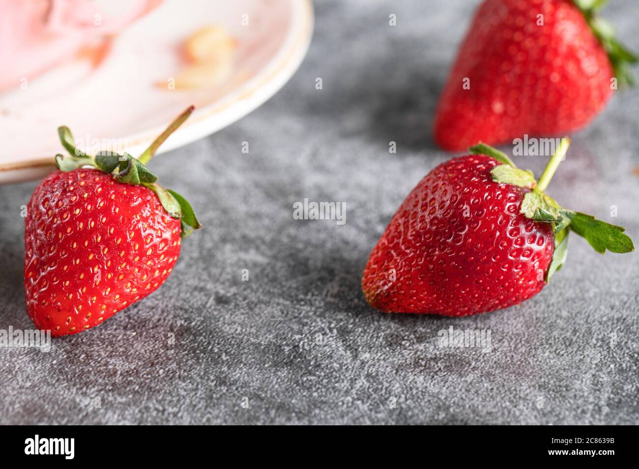 Strawberries on the concrete background Stock Photo - Alamy
