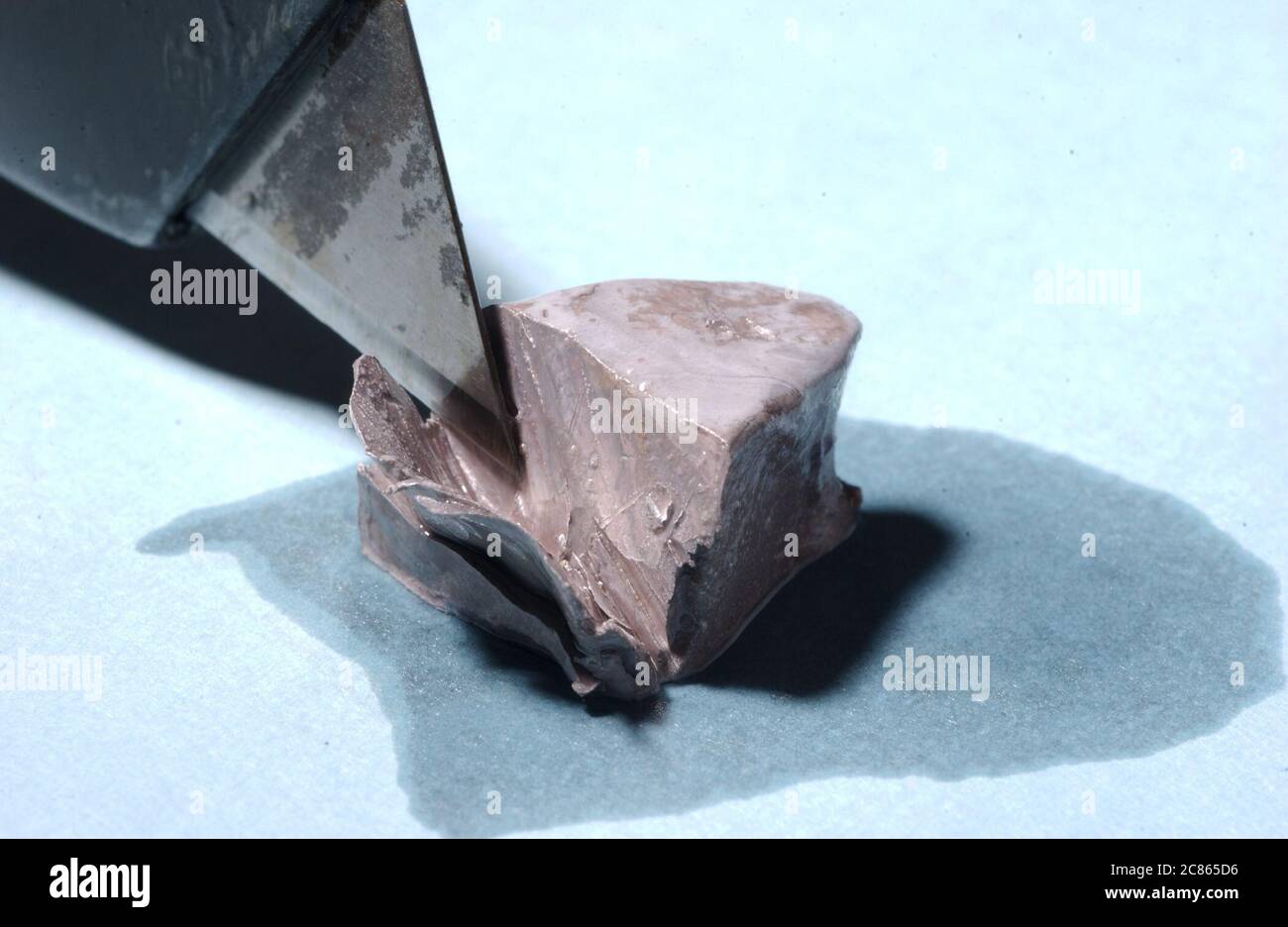 Cutting a small block of sodium in the laboratory to show how quickly it tarnishes when exposed to air. ©Bob Daemmrich Stock Photo