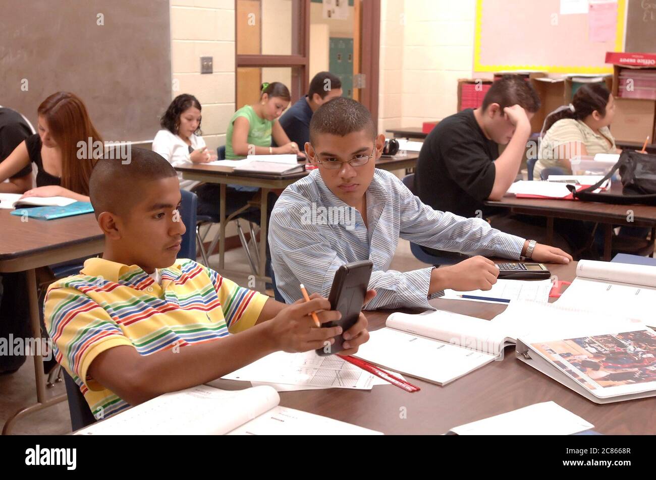 Brownsville, Texas USA, December 2 2005: Students at Lopez High School work on math problems in Algebra II classroom using hand-held scientific calculators. The student population of Lopez HS is over 99% Hispanic.  ©Bob Daemmrich Stock Photo