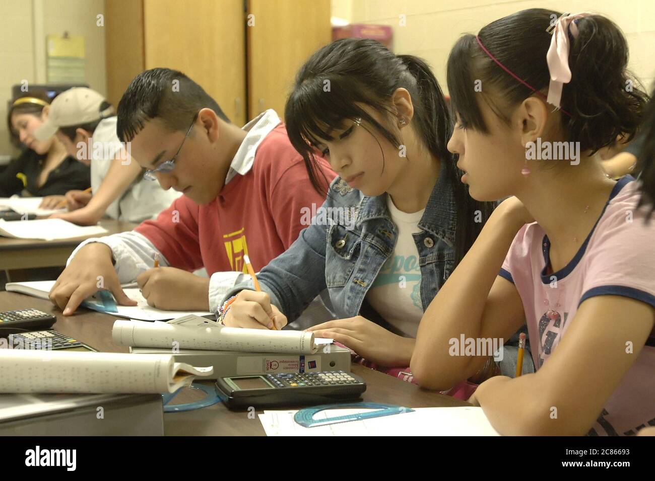 Brownsville, Texas USA, December 2 2005: Students at Lopez High School work on math problems in Algebra II classroom using hand-held scientific calculators. The student population of Lopez HS is over 99% Hispanic.  ©Bob Daemmrich Stock Photo