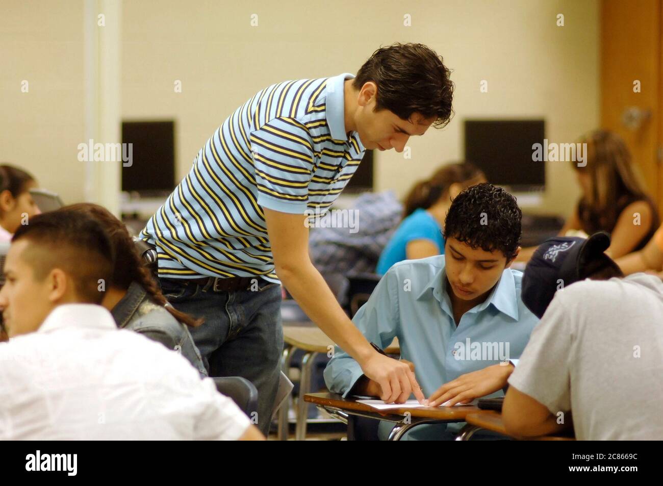 Brownsville, Texas USA, December 2, 2005: First-year male teacher interacting with students in math class during study period at Lopez High School. The student population at Lopez is over 99% Hispanic.  ©Bob Daemmrich Stock Photo