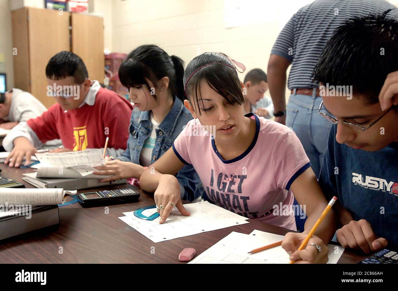 Brownsville, Texas USA, December 2 2005: Students at Lopez High School collaborate on math problems in Algebra II classroom using hand-held scientific calculators. The student population of Lopez HS is over 99% Hispanic.  ©Bob Daemmrich Stock Photo