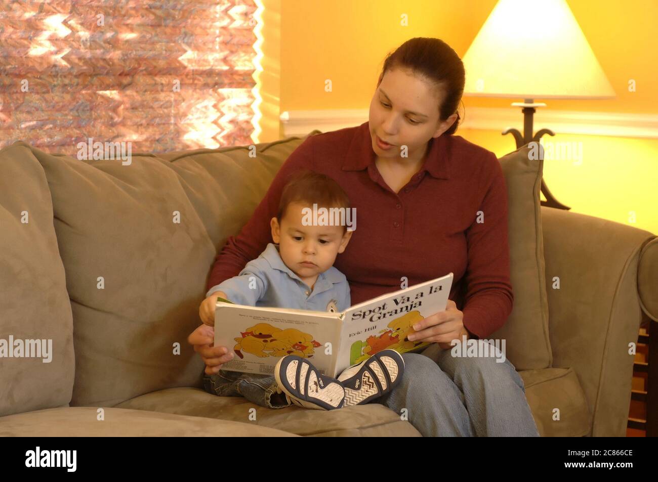 Austin, Texas USA, January 2006:Hispanic mother in early 30's reads book in Spanish to her 22-month old son at home.  Model released OK.   ©Bob Daemmrich Stock Photo