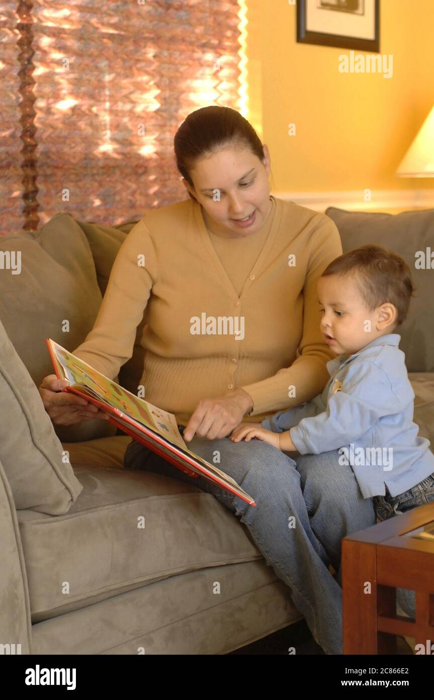 Austin, Texas USA, January 2006:Hispanic mother in early 30's reads book to her 22-month old son at home.  Model released OK.   ©Bob Daemmrich Stock Photo